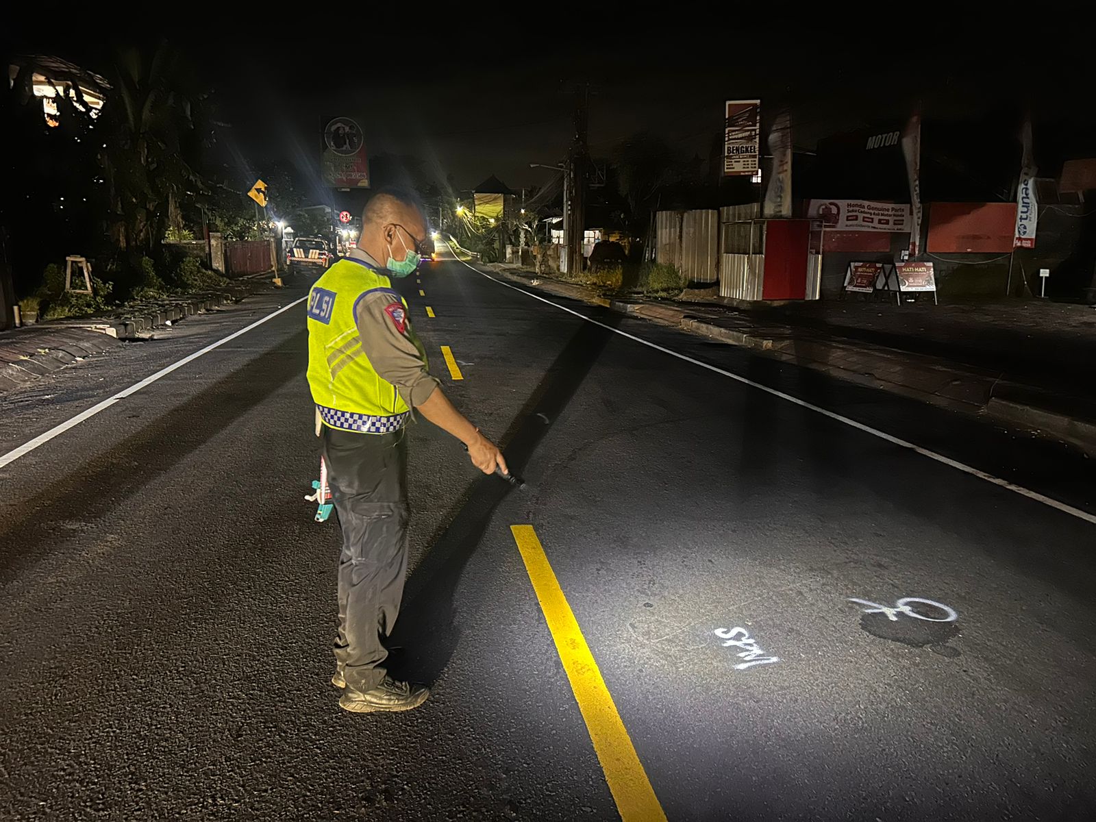 Polisi yang melakukan olah TKP di lokasi adu jangkrik jalur tengkorak Denpasar-GIlimanuk tepatnya di Desa Berembeng, Selemadeg.