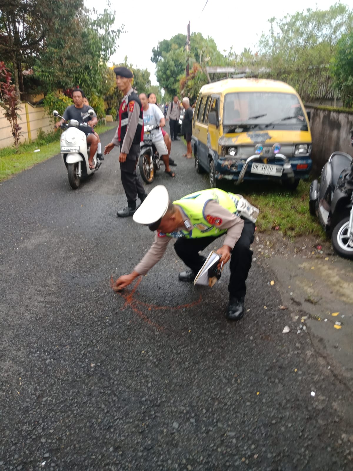 Polisi melakukan olah TKP di lokasi laka lantas antara mobil dan sepeda motor, yang mengakibatkan satu nyawa melayang.