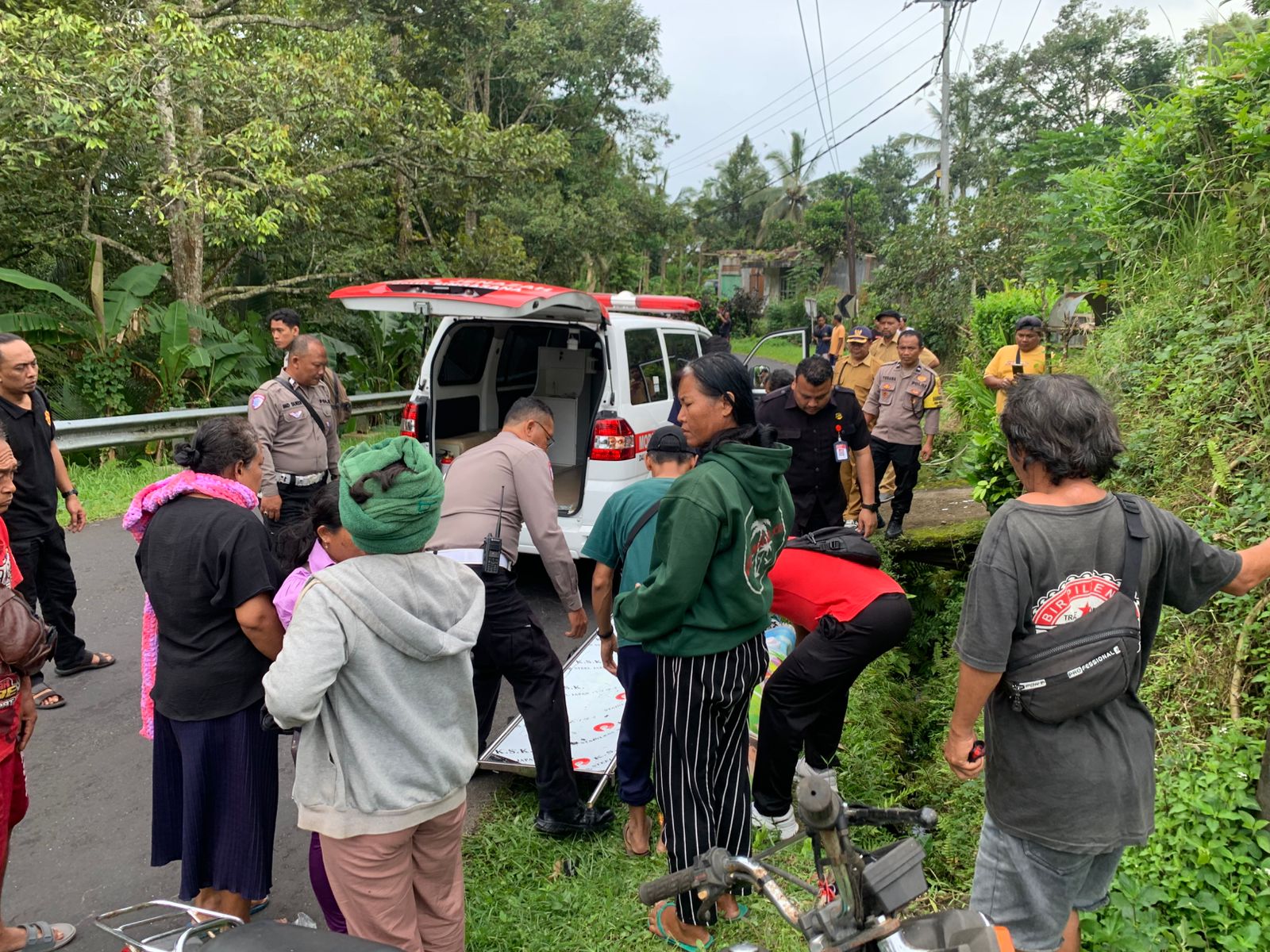Polisi dan warga mengevakuasi korban kecelakaan tunggal di Pupuan Tabanan. Perempuan pengendara motor tewas di selokan. 
