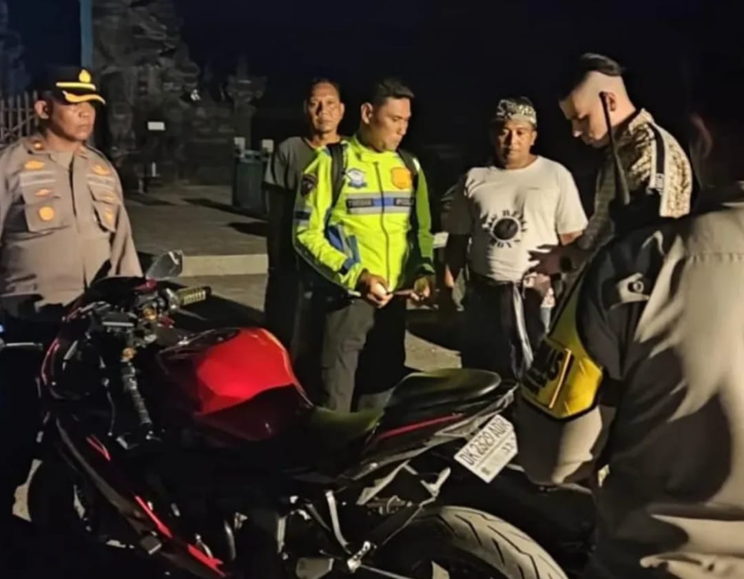 Petugas kepolisian menindak seorang WNA asal Ukraina saat razia aksi ugal-ugalan di Jalan Raya Pantai Cemagi, Mengwi, Badung, Minggu (22/3) malam.