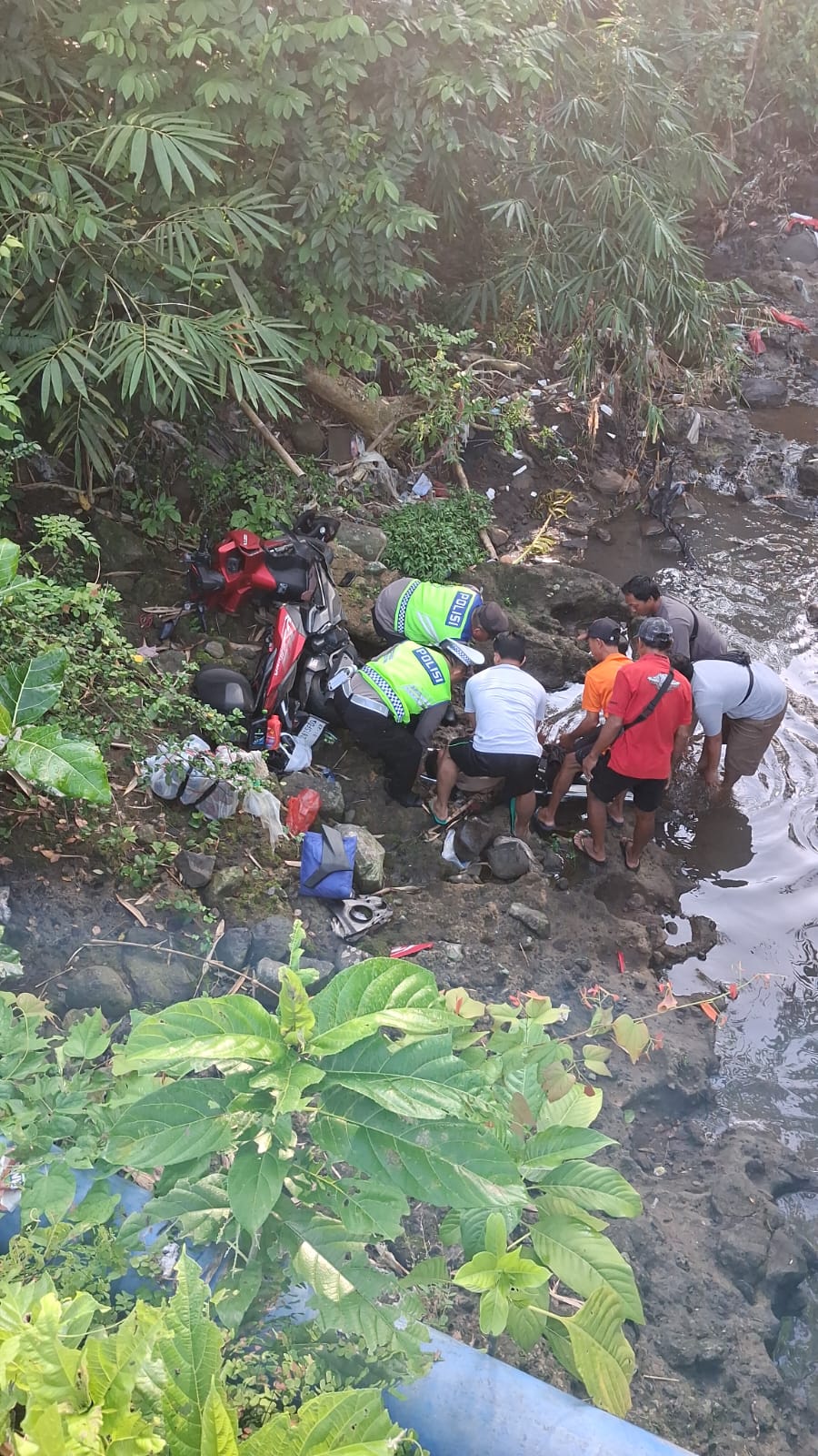 Polisi melakukan evakuasi korban pemotor yang terjun bebas bawah Jembatan Pangkung Berembeng, Selemadeg.