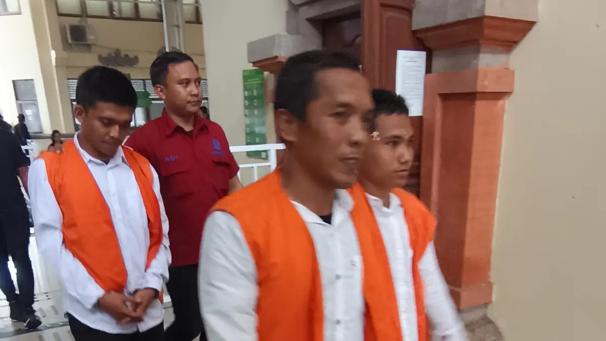 Ivan Adi Fermansah (belakang) usai menjalani sidang tuntutan di PN Denpasar. (Foto M. Sandijaya) 