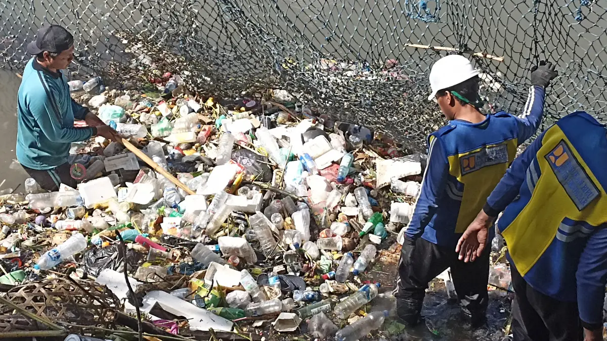 Petugas PUPR Kota Denpasar saat membersihkan tumpukan sampah yang menyumbat aliran sungai di kawasan Banjar Buagan, Jalan Imambonjol, Denpasar. (Foto Adrian Suwanto) 