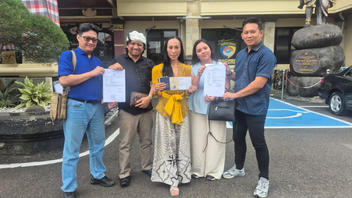 Nova Indriani menunjukkan dokumen pernikahan sah yang terdaftar secara legal di Uni Eropa saat memenuhi panggilan penyidik di halaman Mapolres Badung, Senin (20/4) kemarin. (Foto I Wayan Widyantara) 