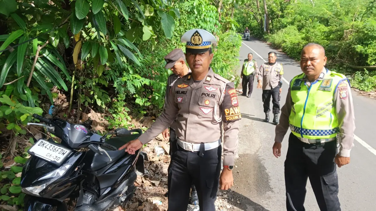 Petugas kepolisian bersama warga saat melakukan evakuasi korban pengendara sepeda motor yang meninggal dunia akibat tertimpa pohon tumbang di Jalan Toyaning II, Desa Ungasan, Kuta Selatan, Badung, Senin (27/4/2026) pagi. (Foto Foto Polsek Kuta Selatan)&nbsp;