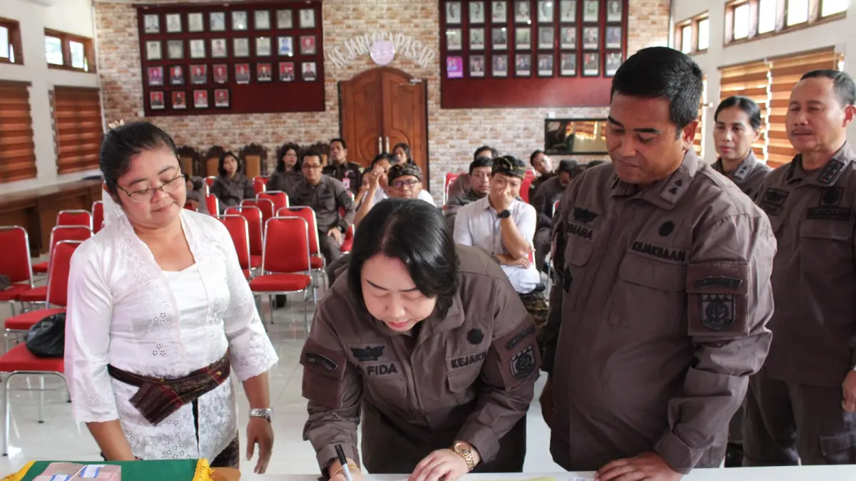 Tim Jaksa Penuntut Umum Kejari Denpasar saat menandatangani berkas serah terima uang tunai dan sertifikat tanah untuk diserahkan kepada pengurus LPD Desa Adat Yangbatu.(Foto Kejari Denpasar)&nbsp;