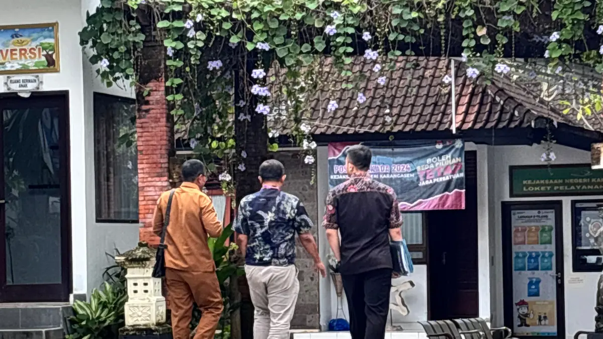 I Komang Sutirtayasa (berbaju PNS) didampingi oleh dua orang kuasa hukumnya saat menjalani pemeriksaan sebagai saksi di Kantor Kejaksaan Negeri Karangasem, Senin (18/5) kemarin. (Foto Zulfika Rahman)&nbsp;