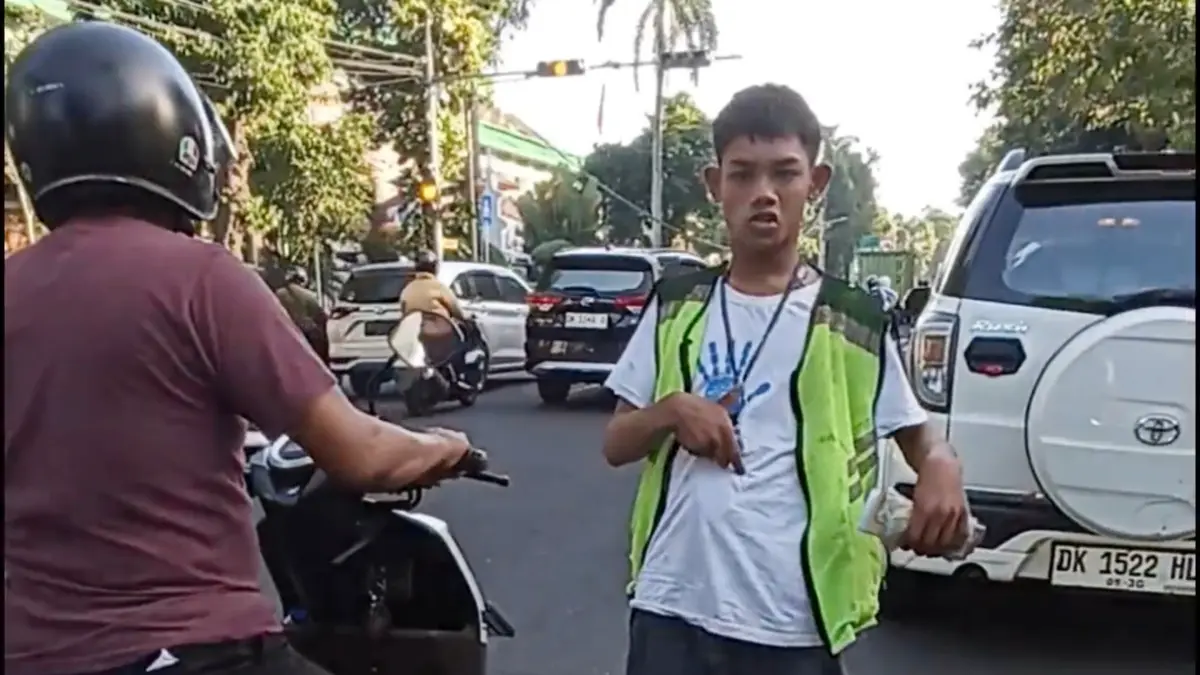 Seorang anak penyandang disabilitas ditugaskan sebagai tukang parkir serep tanpa izin dan tidak sesuai kriteria di Denpasar. (Foto Adrian Suwanto)