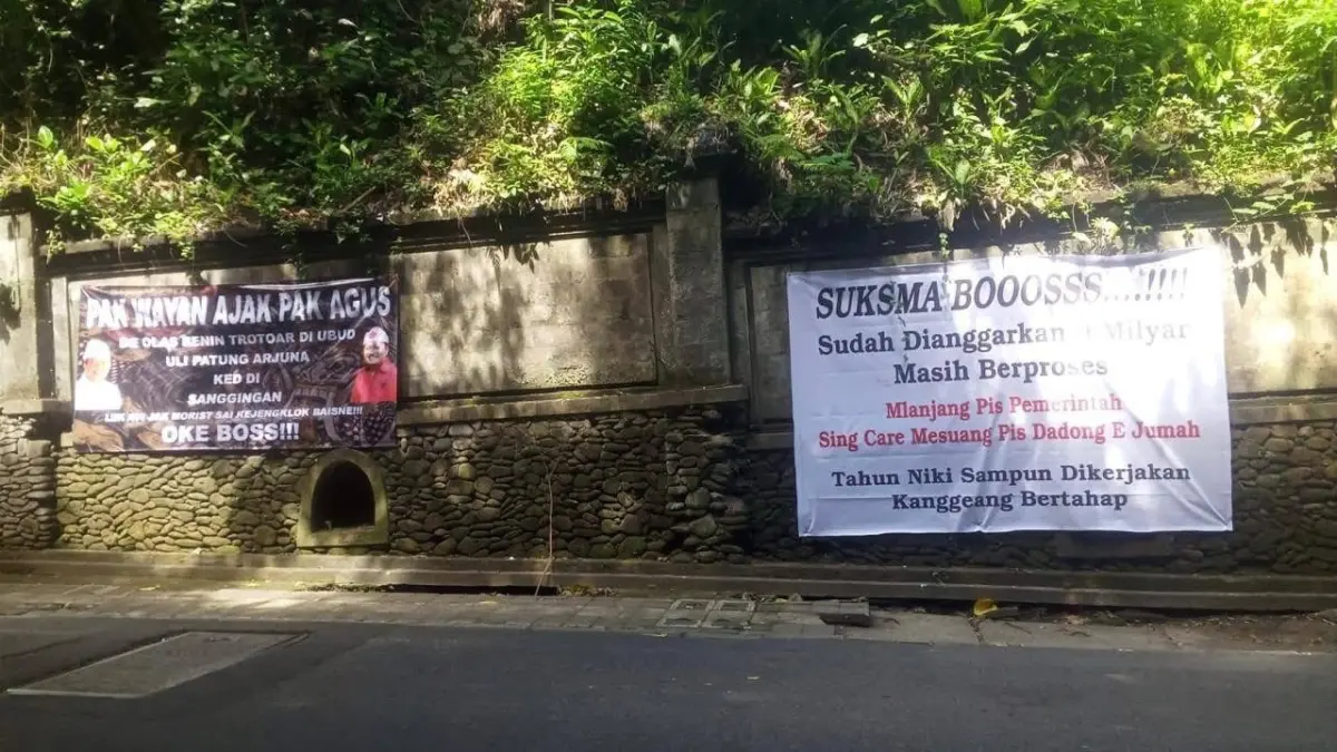 Dua spanduk dengan narasi kritik dan mendukung pemerintah ditempel di Jalan Raya Campuhan Ubud. (Istimewa) 