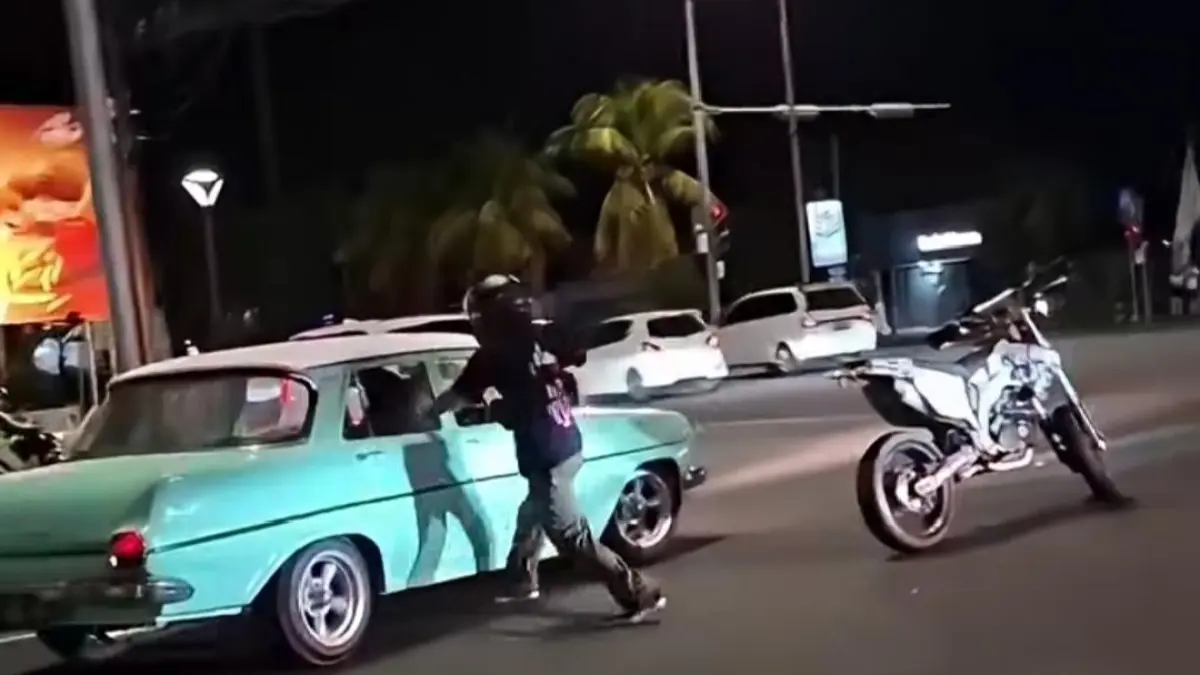 Tangkapan layar rekaman video yang viral memperlihatkan momen keributan antara pengendara motor trail dan pengemudi mobil Holden di Jalan Danau Buyan, Sanur, Denpasar Selatan, Sabtu (30/5) malam. (Istimewa) 