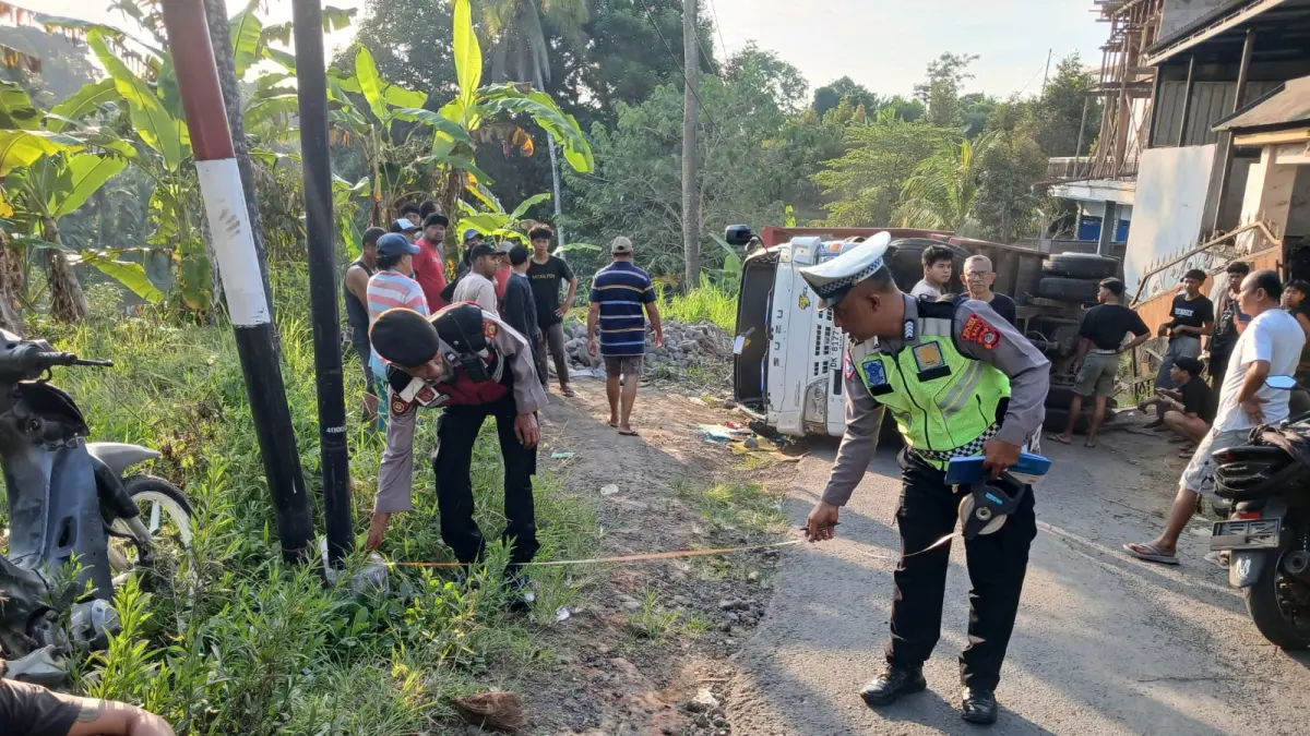 Truk bermuatan batu terguling setelah mengalami kerusakan as roda saat melintas di jalan menanjak.(Foto Polres Buleleng) 