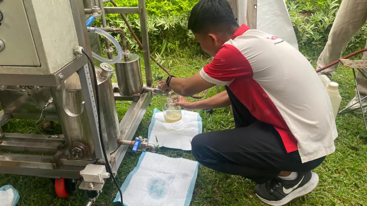 Pihak Yayasan Get Plastic Indonesia mempraktikkan cara kerja mesin pirolisis yang dapat mengubah sampah plastik menjadi bahan bakar minyak. (Foto Zulfika Rahman) 