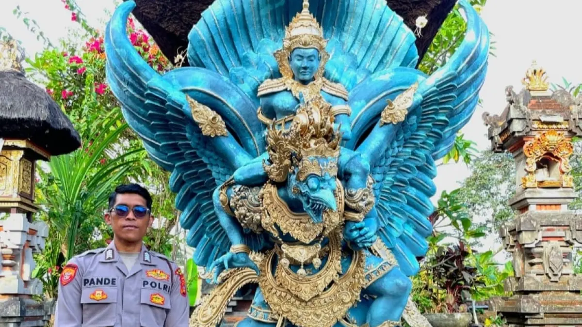 Bripka Pande Made Ari Sudewa, anggota Ditresnarkoba Polda Bali, berpose di samping patung GWK setinggi 2,3 meter hasil karyanya yang dipamerkan di Bazar Kreasi Bhayangkari Nusantara 2026, JICC Jakarta.(Istimewa)