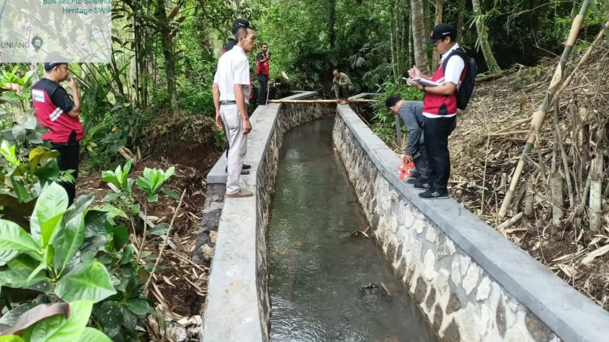 Petugas memeriksa salah satu jaringan irigasi yang direhabilitasi di Tabanan.(Foto Juliadi)