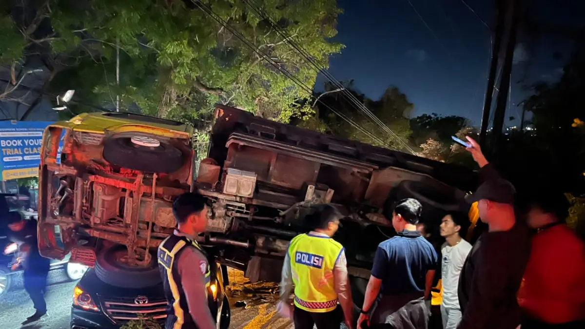 Truk dump dengan nomor polisi DR 8092 KU terguling setelah patah as roda belakang kiri saat melintas di Jalan Uluwatu, Jimbaran, Rabu (12/8) kemarin. (Istimewa)