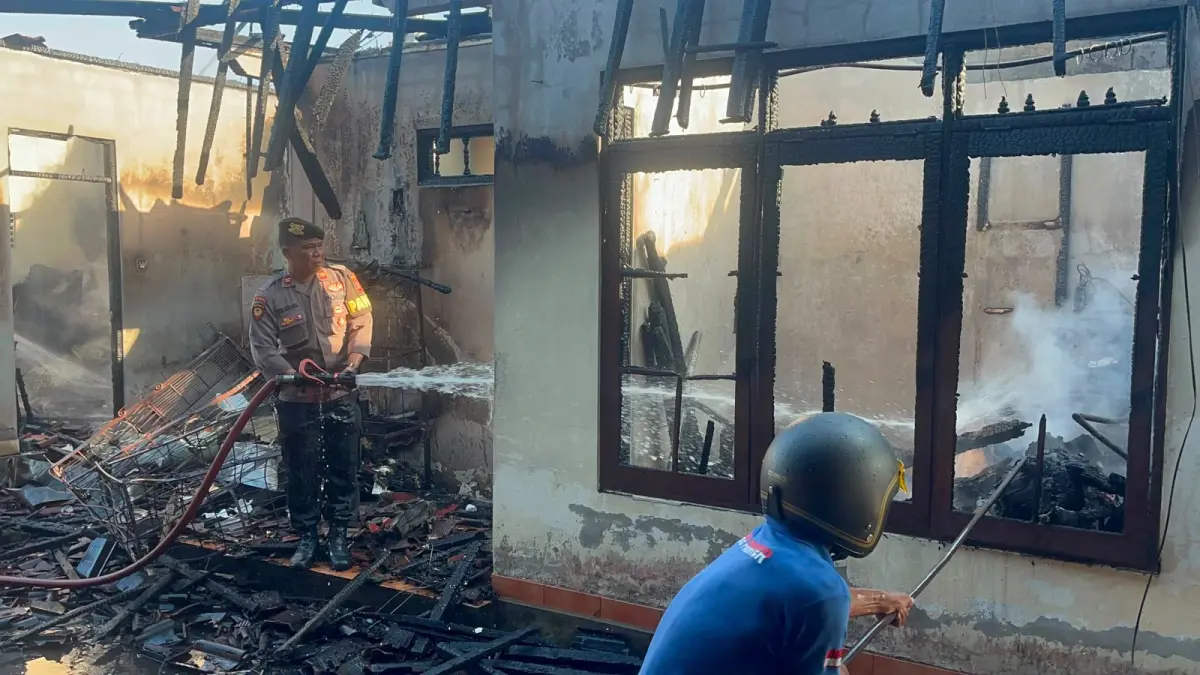 Anggota kepolisian bersama petugas Pemadam Kebakaran Tabanan berusaha memadamkan kobaran api yang melahap bangunan rumah serta merajan di Banjar Dinas Gubug Belodan, Desa Gubug, Tabanan.(Istimewa)