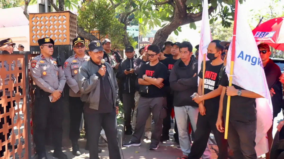 Personel Polresta Denpasar mengawal aksi penyampaian aspirasi Federasi Serikat Pekerja Mandiri (FSPM) Regional Bali di depan Kantor PT Angkasa Pura Support (APS) Cabang Denpasar, Jalan Bypass Ngurah Rai, Tuban, Kuta, Badung, Kamis (27/8) kemarin. (Foto Adrian Suwanto)