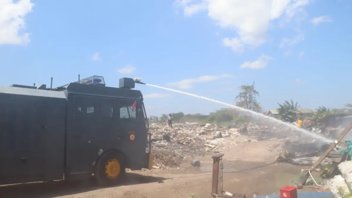 Belum Jinak: Petugas menggunakan water canon Sat Samapta Polresta Denpasar untuk membantu memadamkan titik api di kawasan gudang rongsokan Jalan Nakula, Gang Jatayu.(Foto Adrian Suwanto)

&nbsp;
