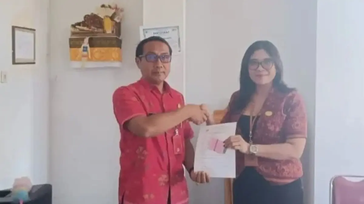 Kabid Hubungan Industrial & Kesejahteraan Pekerja Dinas Koperasi, UMKM & Tenaga Kerja Tabanan Ni Ketut Sri Astuti menyerahkan bantuan BPJS gratis kepada perwakilan Kecamatan Baturiti untuk disalurkan ke pekerja rentan.(Istimewa)