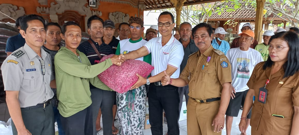 BANTUAN: Kadis Pertanian dan Pangan Badung I Wayan Wijana menyerahkan bantuan sarana dan prasarana pengembangan bawang merah kepada petani di Bale Subak Munggu, Senin (12/6/2023). (Diskominfo Badung)