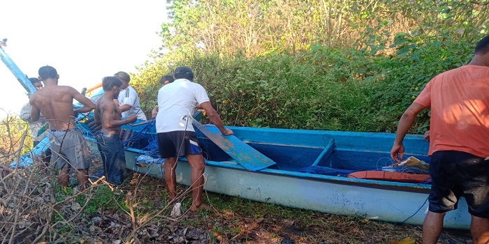 Sampan fiber milik nelayan yang terbalik setelah dievakuasi ke darat.