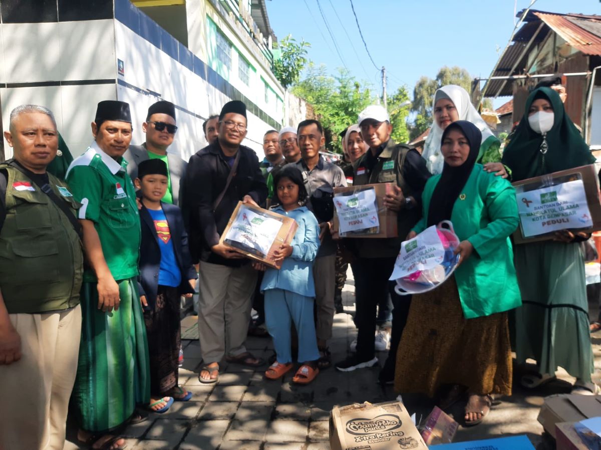 SESUAI KEBUTUHAN: Ketua PCNU Kota Denpasar H. Pujianto (berjaket hitam) bersama sejumlah pengurus, LAZISNU dan LPBI-NU Kota Denpasar saat menyerahkan bantuan kepada warga terdampak kebakaran di RT 05