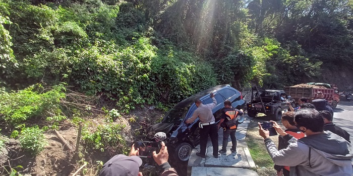 Petugas saat melakukan evakuasi mobil Avanza yang nyemplung ke got di jalan raya Sang Hyang Ambu, Karangasem, Senin (19/6).