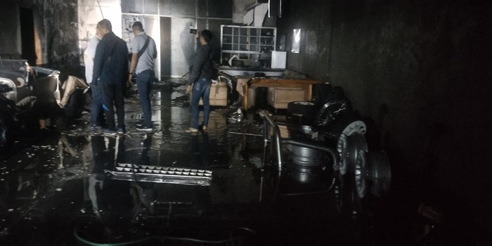 Petugas melakukan pemadaman api yang membakar bengkel modifikasi mobil di jalan Raya Udayana, desa Blahbatuh, Gianyar.