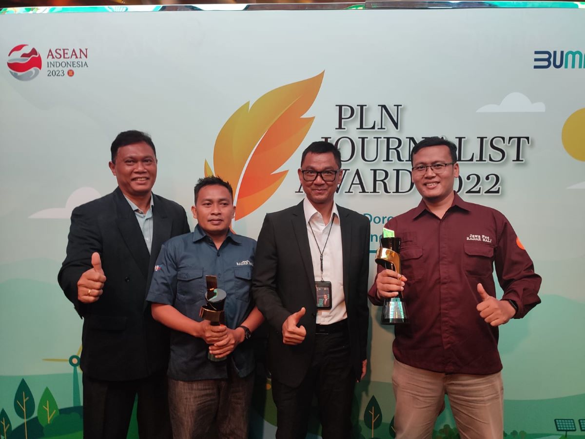 TERBAIK: Dua jurnalis Jawa Pos Radar Bali Maulana Sandijaya (paling kanan) dan Muhammad Basir (dua dari kiri) saat foto bersama usai menerima trofi juara PLN Journalist Award 2022
