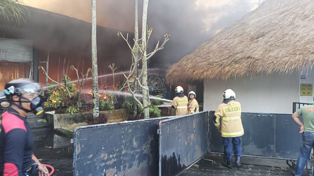 PANIK: Petugas pemadam kebakaran Kabupaten Badung dan aparat lainnya tengah berusaha memadamkan kobaran api yang melumat gudang dan pabrik papan surfing di Ungasan Kuta Selatan (20/6/2023)