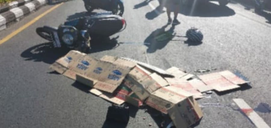 TERLINDAS: Jenazah pengendara Motor bernama Ni Wayan Kariani, 43, ditutupi kardus, tewas ditempat usai terlibat lakalantas.