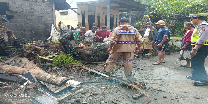 Petugas BPBD Karangasem saat melakukan penanganan pohon tumbang yang menimpa bangunan rumah warga di Desa Duda Utara, Kecamatan Selat, Senin (3/7).