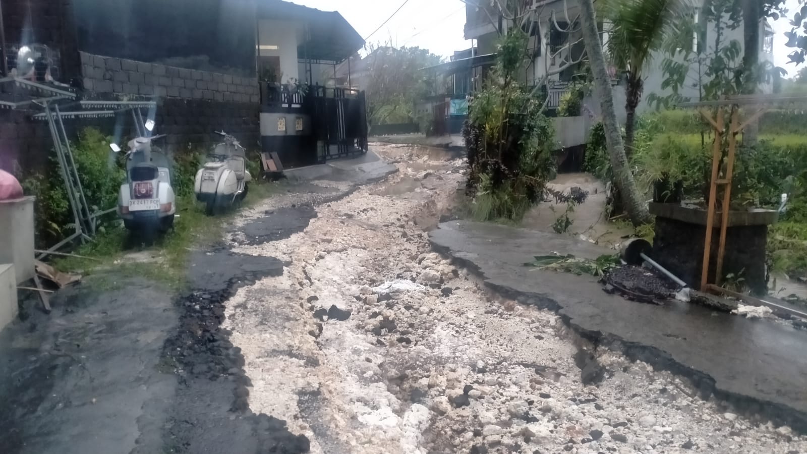 BENYAH LATIG: Kondisi Jalan di Perumahan GMJ Exclusive, Desa Banjar Anyar, Kediri Tabanan yang hancur lebur diterjang banjir.