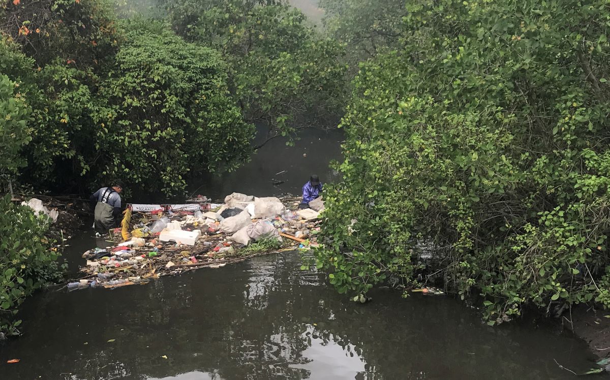 SAMPAH SUNGAI: Relawan Sungai watch mengangkat sampah dari penghalang sampah di sungai kawasan sidakarya.