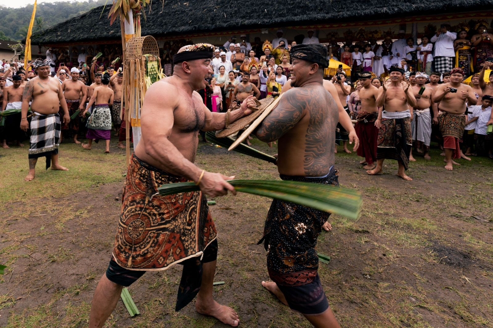 NGATUR AYAH: De Gadjah (kiri) mengikuti perang pandan di Desa Adat Tenganan Dauh Tukad, Jumat (7/7/2023). (Radar Bali Photo)