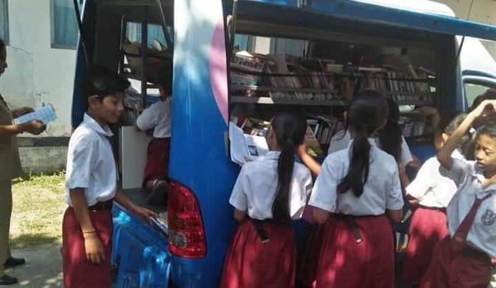 BERKELILING MELAWAN ZAMAN : Mobil perpustakaan keliling milik Dinas Perpustakaan dan Arsip Daerah Tabanan ini tetap berbagi buku bacaan di tengah maraknya gadget.