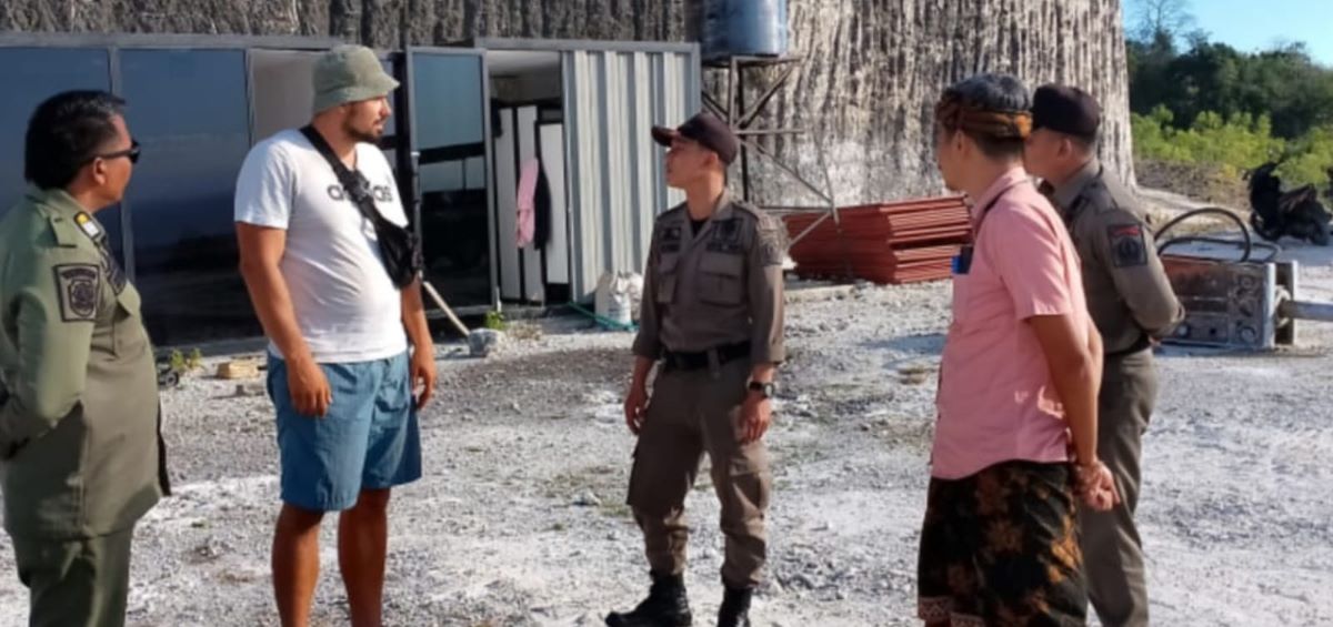 TAK MAU KALAH: Seorang WNA bernama Nova diinterogasi Satpol PP di lokasi proyek pengurukan dan pemotongan tebing di Jalan Cemongkok 8 Pecatu, Kuta Sleatan, Badung, Kamis 20 Juli 2023
