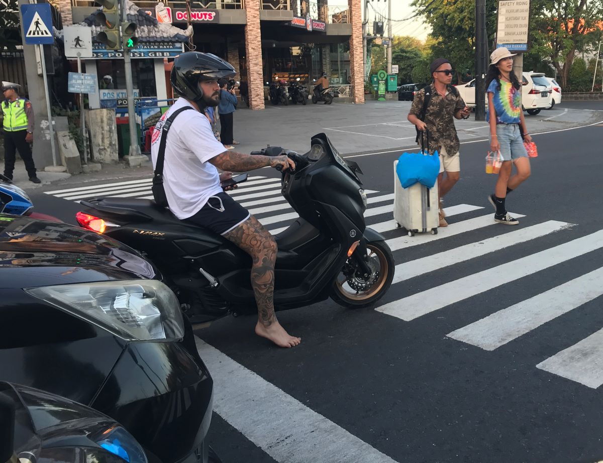 LEWATI MARKA: Seorang bule pengendara motor berhenti melewati garis marka melintang di perempatan lampu lalulintas jalan bypass Ngurah Rai- Hangtuah, Sanur