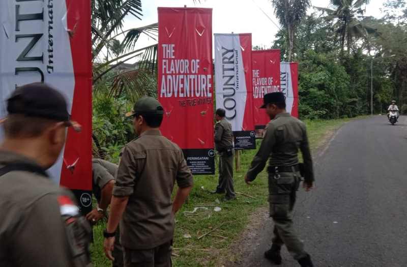 DIBERANGUS SATU MUNCUL SERIBU : Satpol PP Klungkung tengah beraksi memberangus iklan rokok. Tapi biasanya setelah itu tetap muncul lagi.