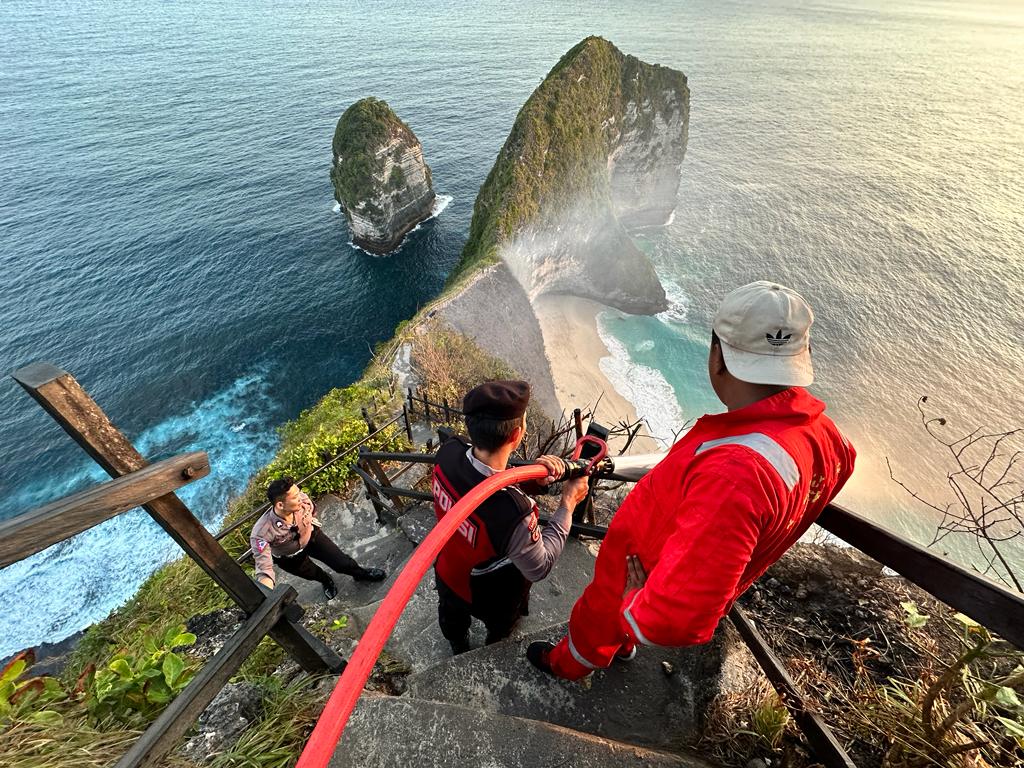 MERANGGAS: Petugas pemadam kebakaran tengah menjinakkan kobaran api di tebing pantai Kelingking, 30 Juli 2023.