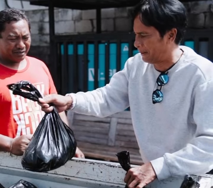 TRADISI YANG TERJAGA: Sejumlah pemain Bali United membagikan daging babi menjelang galungan.