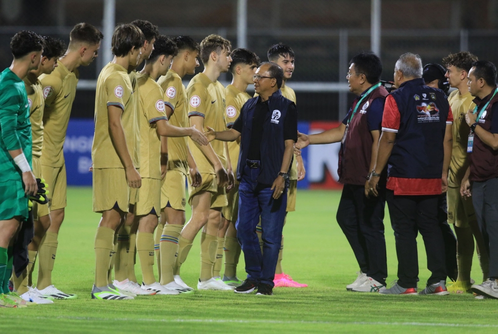 SELAMAT BERTANDING: Gubernur Wayan Koster didampingi Gede Widiada menyalami pemain Barcelona Juvenil A  di stadion Ngurah Rai, Denpasar, Rabu (3/8/2023). (MIFTAHUDDIN HALIM/RADAR BALI)
