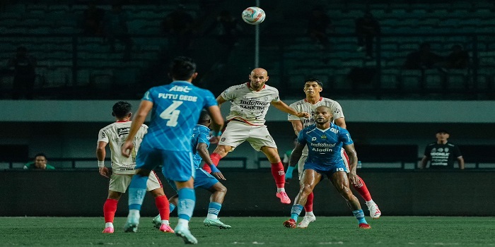 Pemain Bali United berebut bola dengan pemain Persib Bandung.