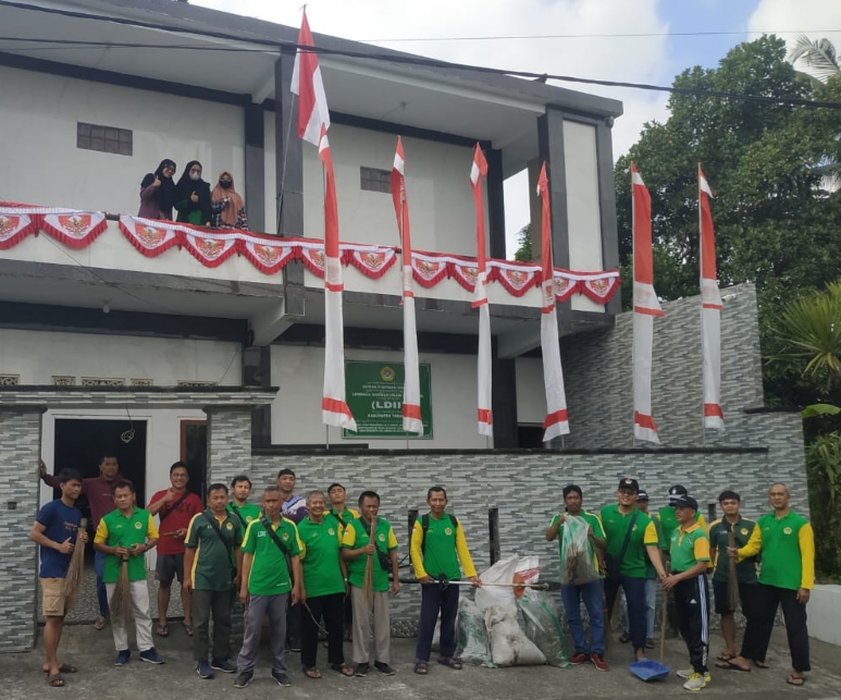 BERSIH-BERSIH: Warga LDII Tabanan juga memberikan bendera merah putih kepada warga banjar Malkangin, Dajan Peken, Jumat (4/8/2023). (Maulana Sandijaya/Radar Bali)