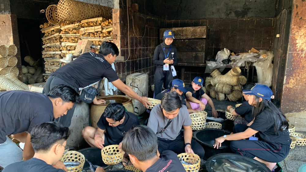 PRAKTEK: Mahasiswa KKN Unud bidang Sosial Budaya mengajak Seka Truna Truni di desa Kusamba belajar tata cara pengolahan ikan. (Radar Bali Photo)