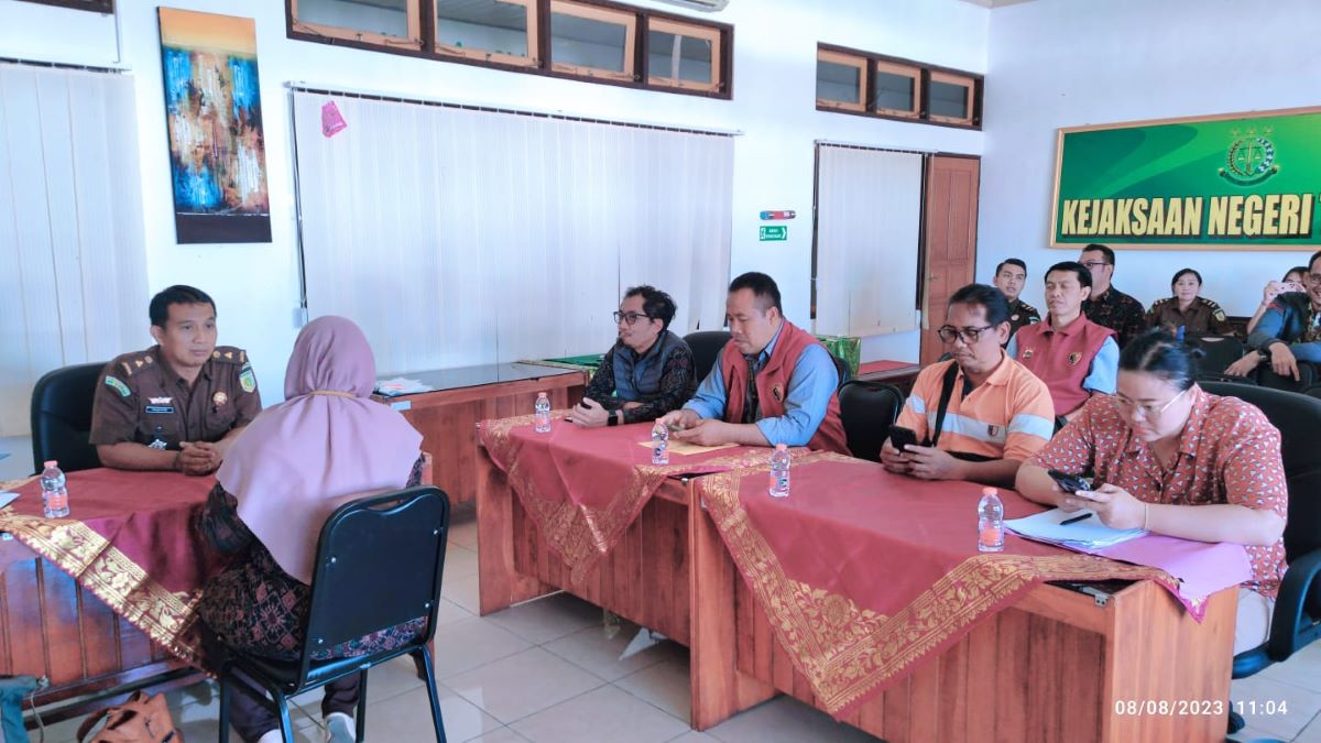 KEMPLANG PAJAK: Tersangka penggelapan pajak IWA (berkerudung membelakangi kamera) saat diserahkan ke Kekajsaan Negeri Tabanan, 9 Agustus 2023.