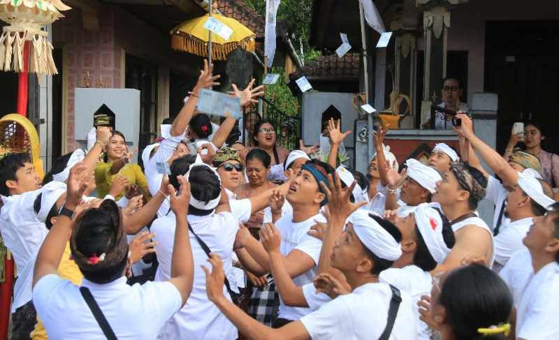SPIRITUAL DAN SOSIAL : Semangat kebersamaan semakin kuat karena berbagi rezeki dengan menyebar uang untuk seluruh warga Bongan, Tabanan (foto:juliadi).