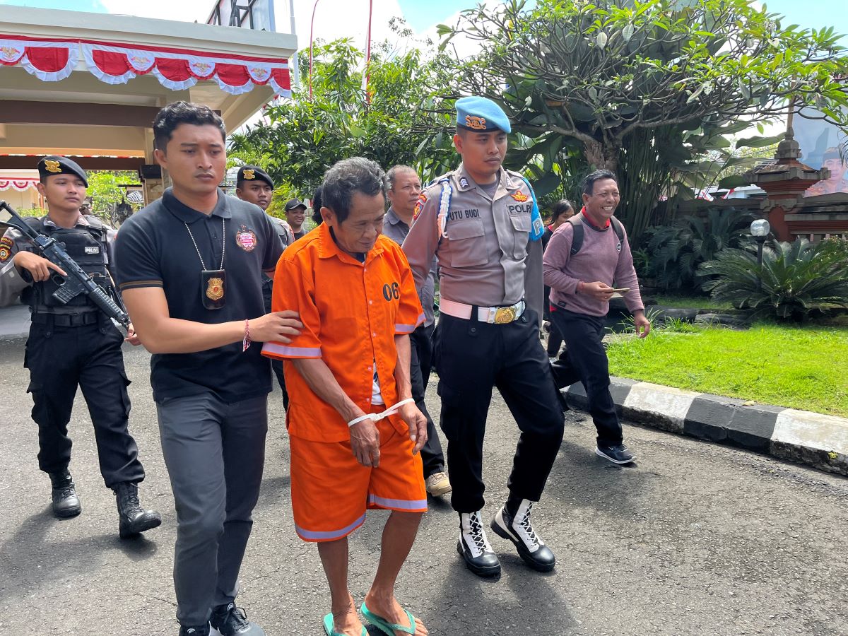 BERKELIT: Tersangka IWS, kakek yang cabuli bocah 8 tahun  saat digelandang di Mapolres Karangasem, Jumat (18/8).