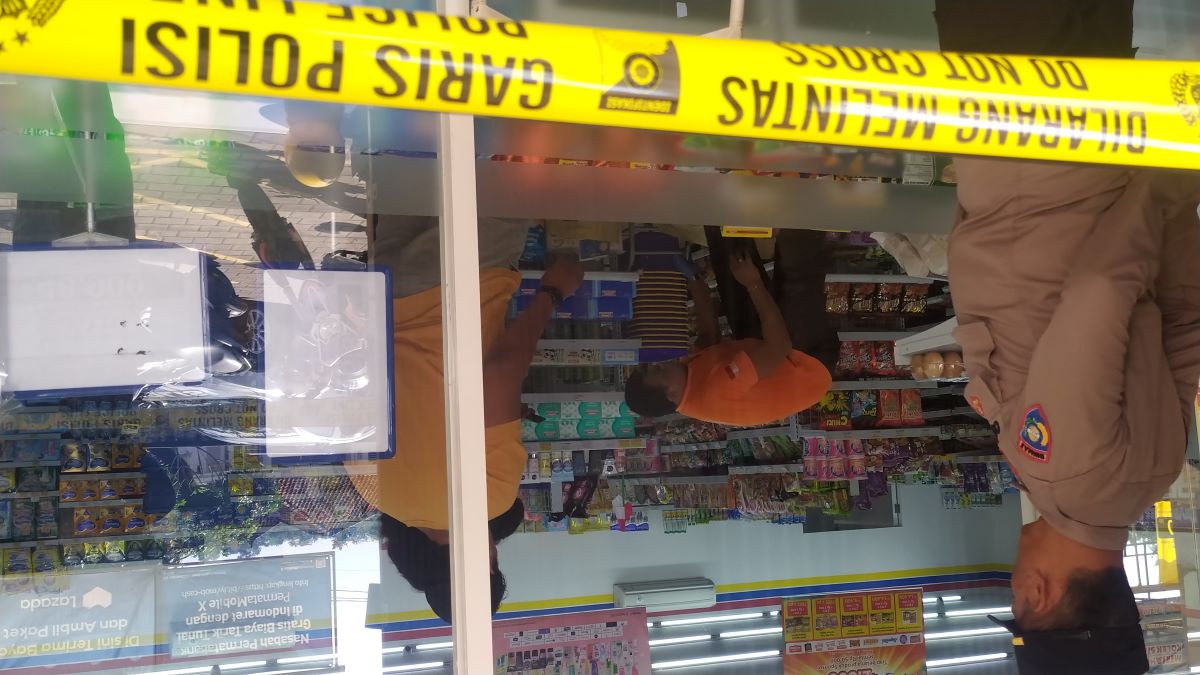 KABUR: Polisi memasang garis polisi dan olah TKP ATM dalam toko yang dibobol maling, Minggu (20/8/2023)