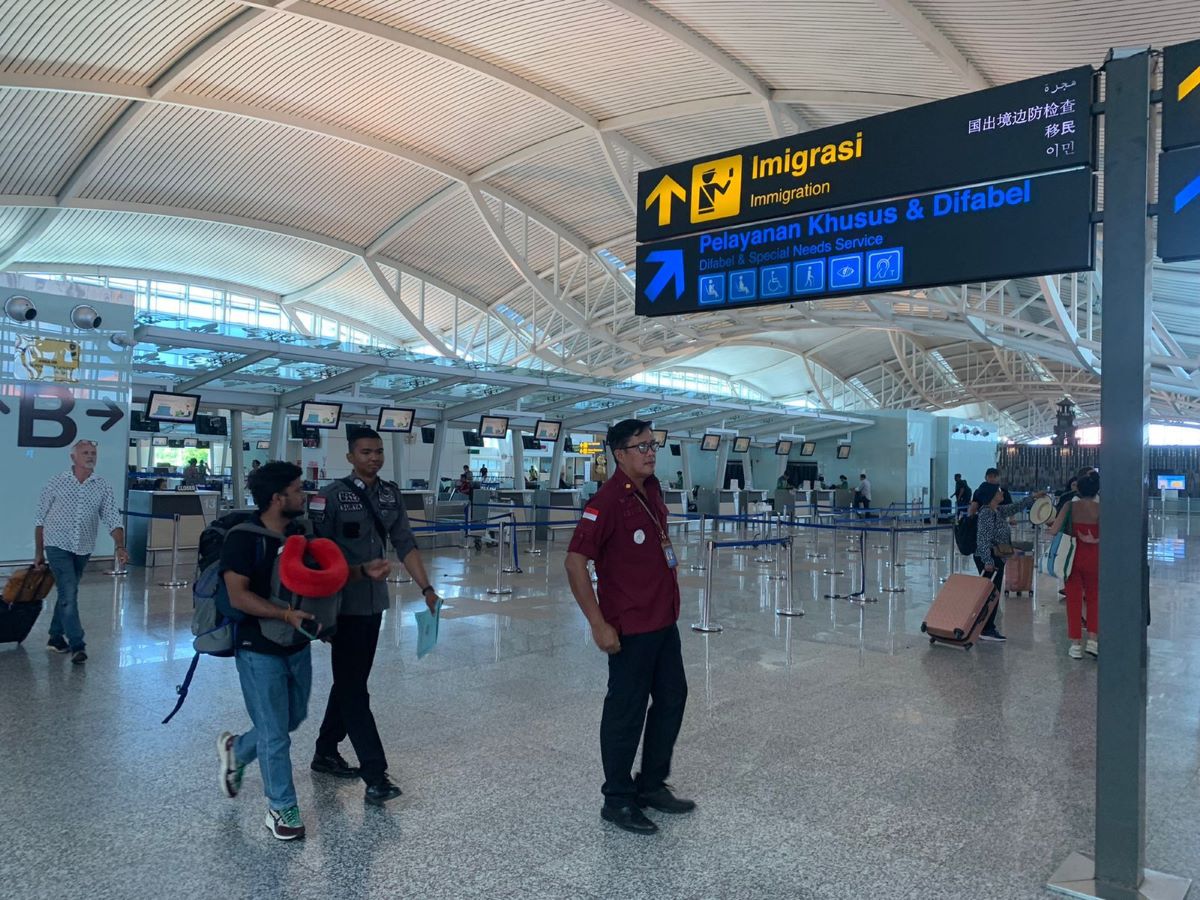 DIPULANGKAN: Lelaki bernama Lewie Brooks, 24, berkewarganegaraan India dikawal ketat hingga Terminal Keberangkatan Bandara I Gusti Ngurah Rai, Rabu 23 Agustus 2023.